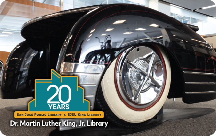 Photo of The '48 Chevy Fleetline is a table activated with electric lifts. View of the white-wall tires and front-end. Logo: 20th Anniversary King Library.