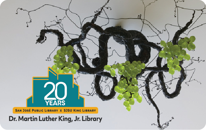 Sprouting from the ceiling in the Business and Economics Section, this twisted and tortured wrought-iron vine is laden with sour green fruit. Logo: 20th Anniversary King Library.